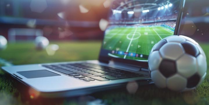 Traditional online betting on football with ball and laptop